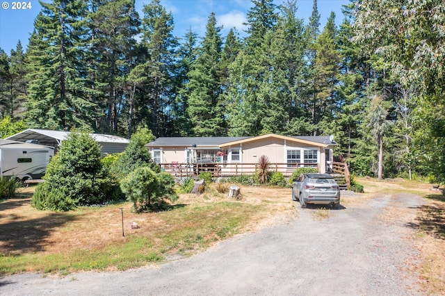 view of front of house with a wooden deck and a carport