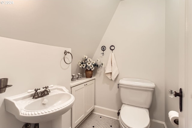 bathroom with vaulted ceiling, toilet, and sink