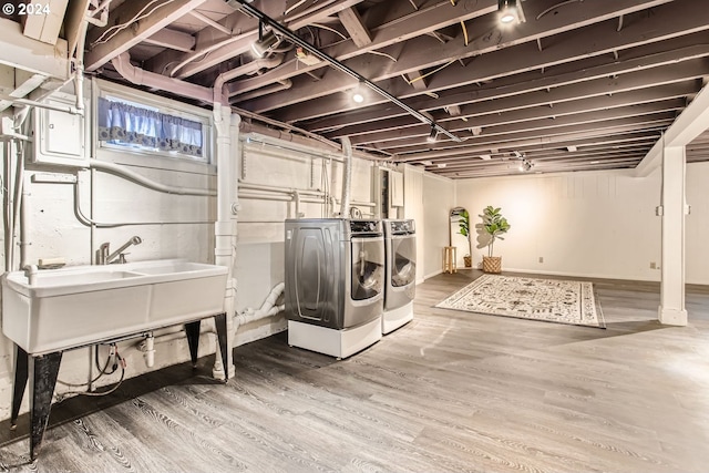 laundry area featuring washing machine and clothes dryer and hardwood / wood-style flooring