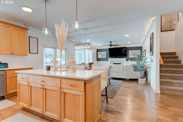 kitchen featuring pendant lighting, a center island, light brown cabinetry, and backsplash