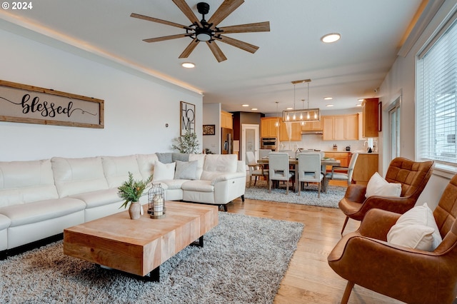 living room with light wood-type flooring and ceiling fan