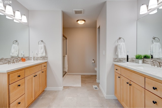 bathroom featuring toilet, a shower with shower door, tasteful backsplash, and vanity