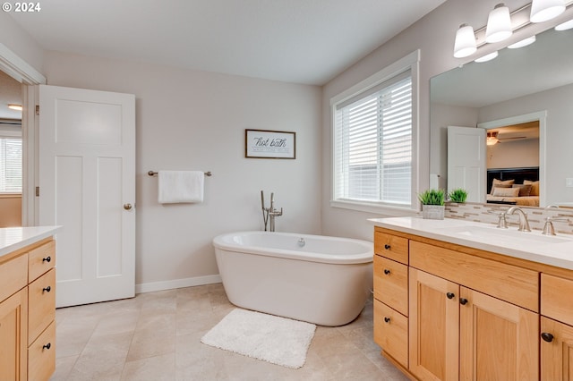 bathroom featuring tasteful backsplash, a bathing tub, tile patterned floors, ceiling fan, and vanity