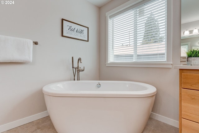 bathroom featuring vanity, tile patterned floors, and a bath