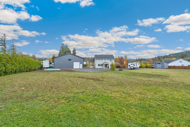 view of yard with a garage and an outbuilding