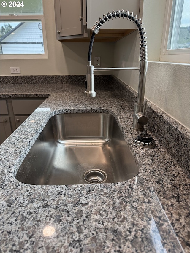 room details featuring dark stone countertops and sink