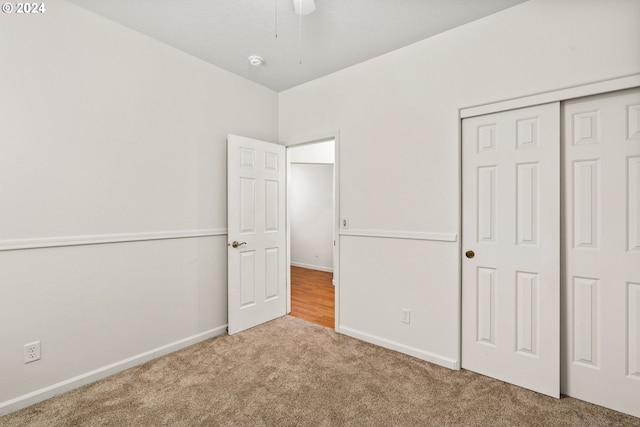 unfurnished bedroom featuring carpet floors, a closet, and ceiling fan