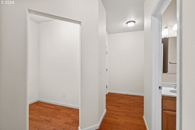 hallway with hardwood / wood-style floors and a textured ceiling