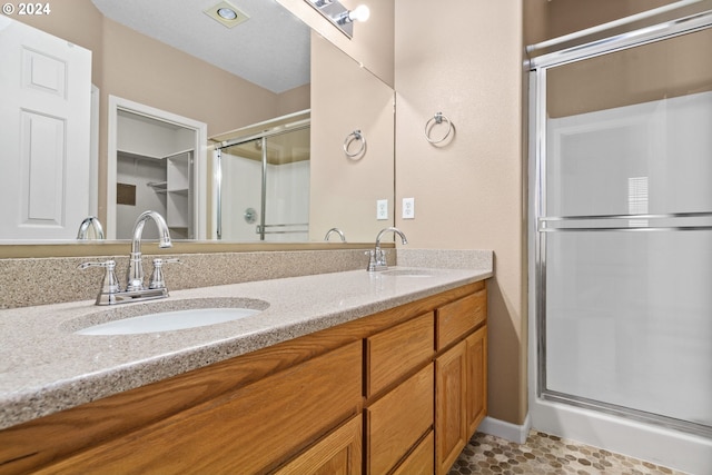 bathroom with vanity and a shower with door