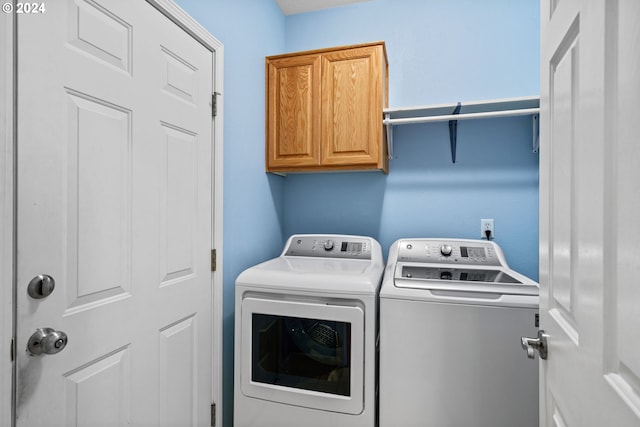 laundry area with washer and dryer and cabinets