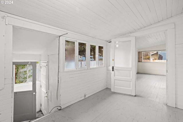 unfurnished sunroom with wooden ceiling, a wealth of natural light, and vaulted ceiling