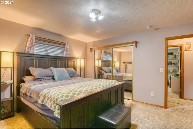 carpeted bedroom with a closet and a textured ceiling