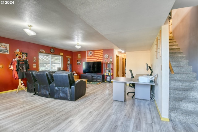 living room featuring light wood-type flooring and a textured ceiling