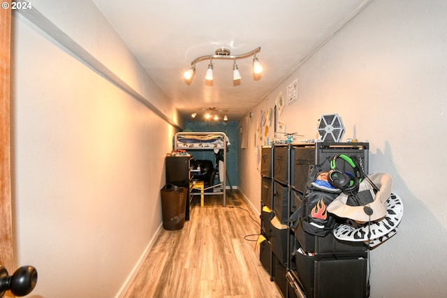 hall featuring wood-type flooring and track lighting