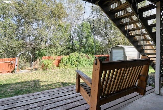 wooden terrace featuring a storage shed and a yard