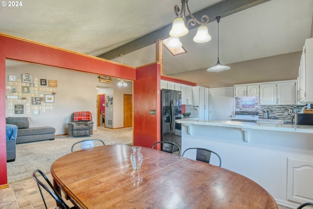 carpeted dining room with vaulted ceiling with beams