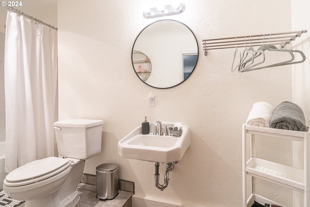 full bath with toilet, a sink, and shower / bath combination with curtain