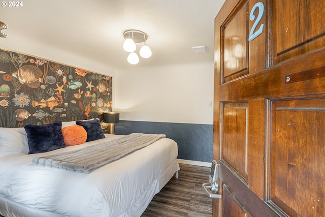 bedroom with dark wood-style flooring and baseboards
