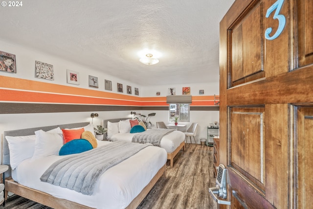 bedroom with wood finished floors and a textured ceiling