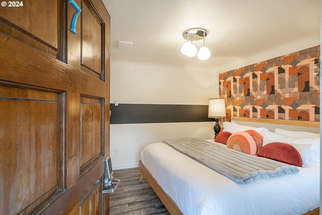 bedroom featuring baseboards and dark wood-type flooring