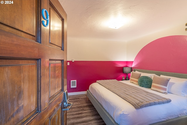 bedroom featuring dark wood-style flooring and baseboards