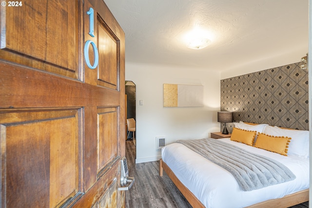 bedroom with dark wood finished floors and baseboards