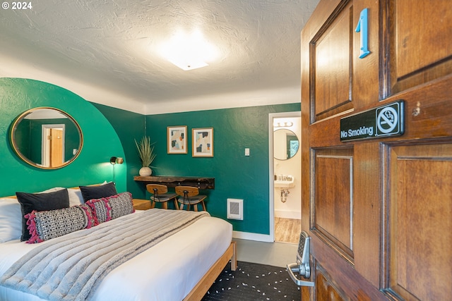 bedroom featuring baseboards, a textured ceiling, and heating unit