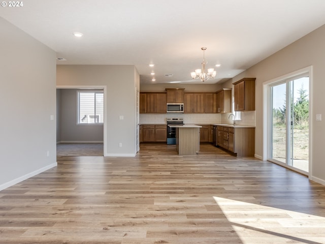 kitchen featuring a notable chandelier, appliances with stainless steel finishes, light hardwood / wood-style floors, and a healthy amount of sunlight