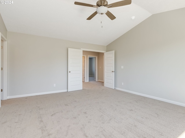 empty room with ceiling fan, lofted ceiling, and light carpet