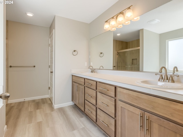 bathroom featuring wood-type flooring, an enclosed shower, and vanity