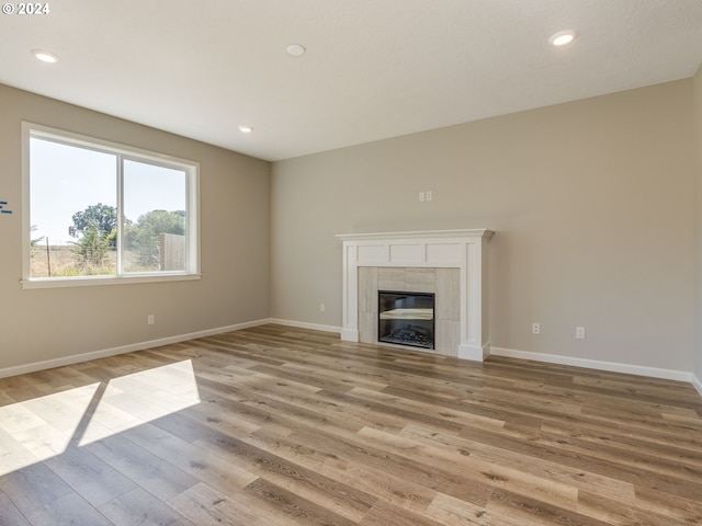 unfurnished living room featuring light wood-type flooring and a fireplace