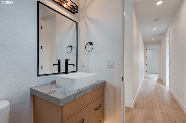 bathroom featuring visible vents, toilet, recessed lighting, wood finished floors, and vanity