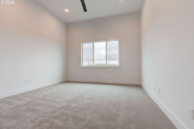 carpeted spare room featuring ceiling fan