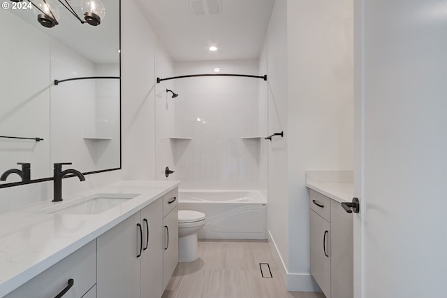 full bathroom with tiled shower / bath, vanity, and toilet