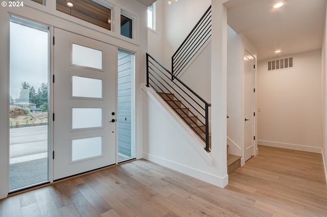 foyer entrance featuring light wood-type flooring, visible vents, recessed lighting, stairway, and baseboards