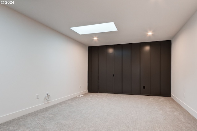 carpeted spare room with a skylight