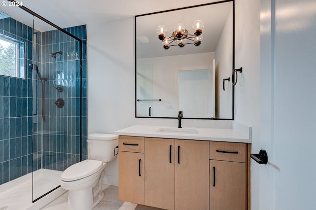 bathroom with vanity, tiled shower, a notable chandelier, and toilet