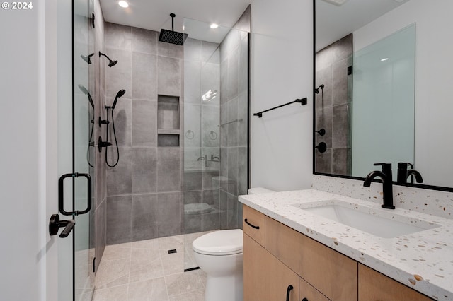 bathroom with vanity, tile patterned flooring, toilet, and a shower with door