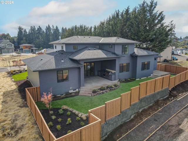 rear view of house featuring a patio and a lawn