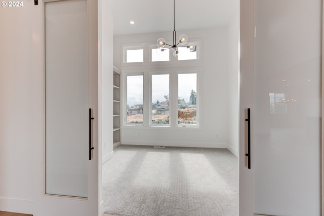 carpeted empty room with a chandelier and built in features