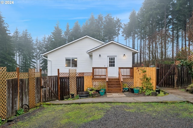 back of house with a lawn and a wooden deck