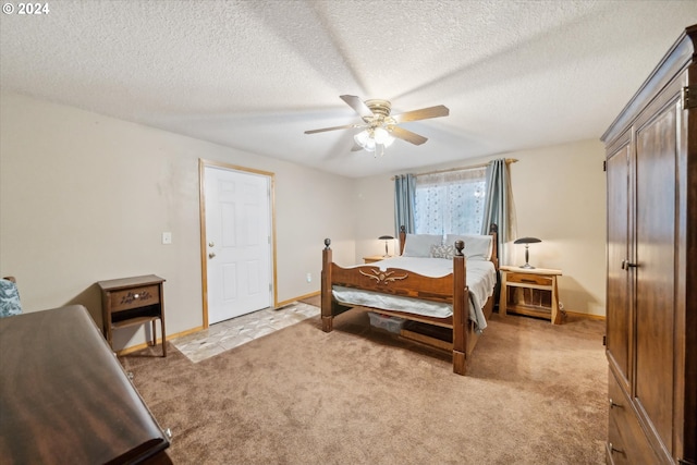 bedroom featuring a textured ceiling, light colored carpet, and ceiling fan