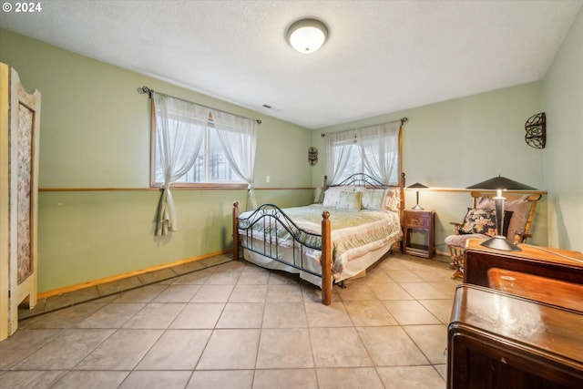 bedroom with light tile patterned floors and a textured ceiling