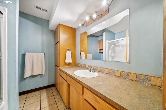 bathroom featuring tile patterned floors, vanity, and walk in shower