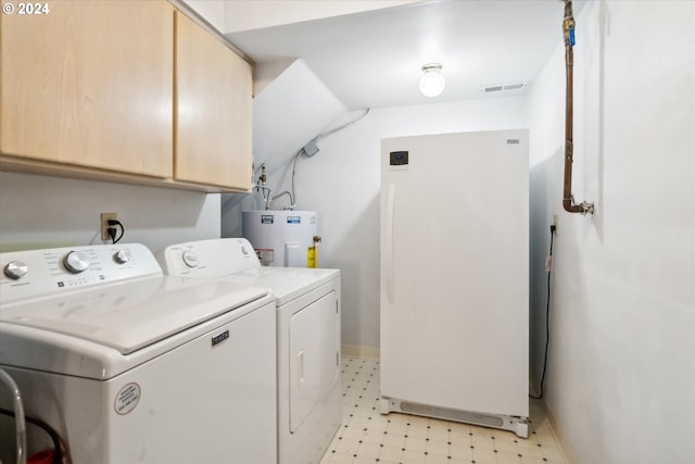 washroom with electric water heater, washer and dryer, and cabinets