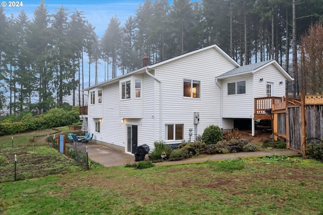 back of house featuring a patio area and a lawn