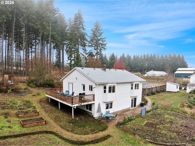 rear view of house featuring a deck, a storage shed, and a patio area