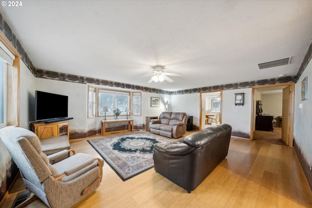 living room with ceiling fan and light hardwood / wood-style flooring