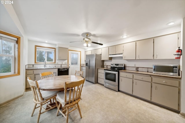 kitchen with appliances with stainless steel finishes, gray cabinets, ceiling fan, and sink