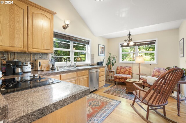 kitchen with stainless steel dishwasher, black electric cooktop, light hardwood / wood-style flooring, a chandelier, and lofted ceiling